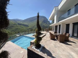 a house with a swimming pool and mountains in the background at Villa Luxury Forest in Peje