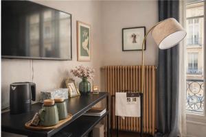 a room with a desk with a lamp and a radiator at Maison Luxembourg - Chambre privée in Paris