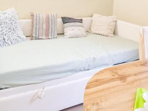 a white couch with pillows and a wooden table at Nel Centro Storico in Luserna San Giovanni
