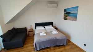 ein Schlafzimmer mit einem Bett und einer Couch in der Unterkunft Villa REST & SPA in Zbiczno