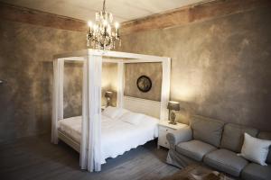 a bedroom with a bed and a couch and a chandelier at Apartments Rose Garden in Děčín