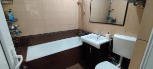 a bathroom with a sink and a tub and a toilet at VLC Apartment in Bucharest