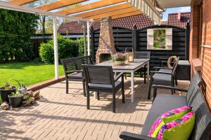 a patio with a table and chairs and a pergola at Andi's Auszeit in Dörpen