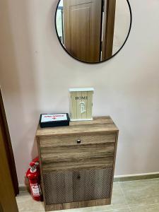 a wooden dresser with a mirror on the wall at Juliya Apartment in Kavadarci