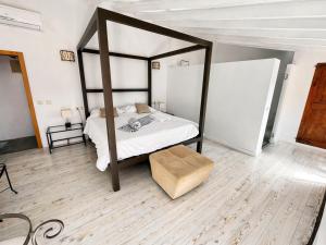 a bedroom with a canopy bed and a wooden floor at Hotel Moscari Nature & Wellness by CheelHotels in Moscari