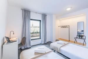 a white room with two beds and a window at HI Lisboa Oriente - Pousada de Juventude in Lisbon +38 photos