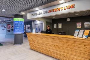 a woman sitting at a reception desk in a building at HI Lisboa Oriente - Pousada de Juventude in Lisbon