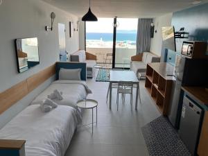 a living room with a bed and a living room with a table at YaYaCaSa in Tangier
