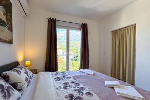 a bedroom with a bed and a large window at Ferienwohnung Penthouse Sunce in Bar