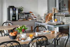 a table and chairs with breakfast foods on it at Logis Hôtel Le Relais in Biscarrosse