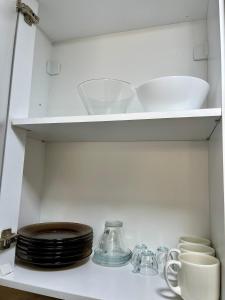 a white cabinet with plates and dishes on it at Juliya Apartment in Kavadarci +16 photos