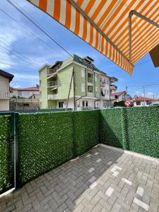 a green fence with a building in the background at Juliya Apartment in Kavadarci