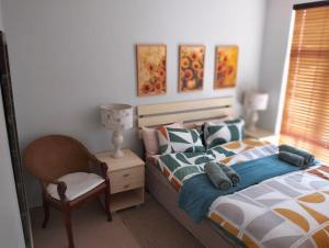 a bedroom with a bed and a chair at On the Beach 20 in Swakopmund +18 photos