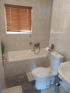 a bathroom with a toilet and a bath tub at On the Beach 20 in Swakopmund