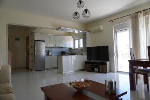 a kitchen with white appliances and a table in a room at El Condor Casa in Rhodes Town +12 photos
