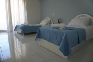 two beds in a room with blue and white at El Condor Casa in Rhodes Town