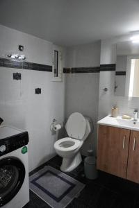 a bathroom with a toilet and a washing machine at El Condor Casa in Rhodes Town