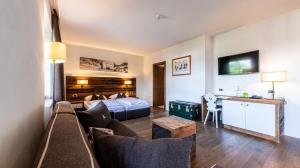 ein Hotelzimmer mit einem Bett und einer Couch in der Unterkunft Hotel ANDER in Bruneck