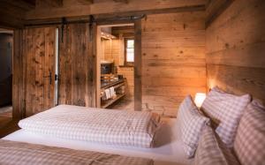 a bedroom with wooden walls and a bed with pillows at Alpin Chalets Oberjoch in Bad Hindelang +45 photos
