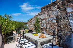 a table and chairs on a patio with a stone wall at Ca'n Ruquet in Campanet
