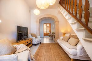 a living room with two couches and a staircase at Ca'n Ruquet in Campanet