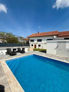 a large blue swimming pool in front of a house at Residence Stina in Široki Brijeg