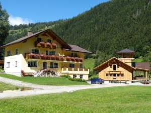 een groot geel huis met een berg op de achtergrond bij Schieplechnerhof in Schladming