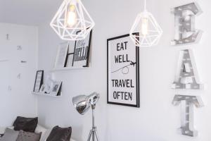 a room with a lamp and a wall with signs at Studio Apartment By Travel Lets Holiday Homes Lagada With Pool in Makry Gialos +10 photos