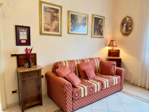 a living room with a couch and pictures on the wall at Suite Apartment Mandorlo in Volterra +12 photos