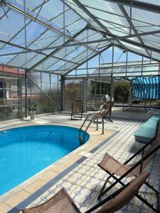 a patio with a pool and chairs and a building at Villa Noza Kalamos in Kalamos
