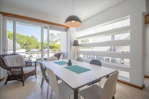 a dining room with a table and chairs and a large window at Villa Granada by Algarve Holidays in Almancil