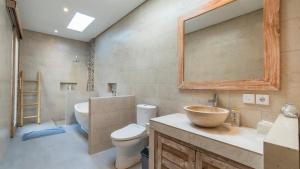 a bathroom with a sink and a toilet and a mirror at Diva Villa Sanggingan Ubud in Ubud +24 photos