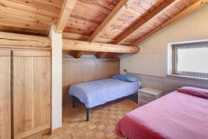 a bedroom with two beds in a room with wooden ceilings at Baita Del Canton in Valdidentro