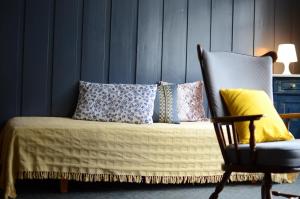 a bed with pillows and a chair in a room at Gasthaus Rössli in Trogen +6 photos