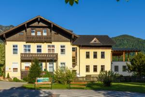 a large house with two benches in front of it at Luise Wehrenfennig & Haus EvA in Bad Goisern