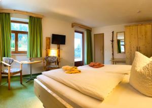 a hotel room with two beds and a table and a desk at Pension Zum Talwächter im Sandsteinidyll in Rathen