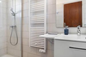 a white bathroom with a shower and a sink at Maison L'arrieulat in Argelès-Gazost +28 photos
