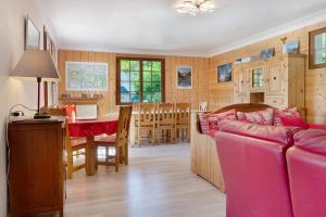a living room and dining room with a pink couch at Maison L'arrieulat in Argelès-Gazost
