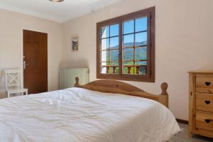a bedroom with a white bed and a window at Maison L'arrieulat in Argelès-Gazost