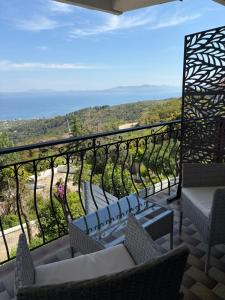 a balcony with chairs and a view of the ocean at Villa Noza Kalamos in Kalamos