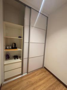 a room with a closet with white walls and wooden floors at Roxy Apartment Kuching in Kuching