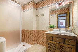 a bathroom with a sink and a toilet and a mirror at Matalascañas Primera Línea de Playa in Matalascañas +21 photos
