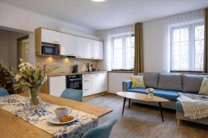 a kitchen and a living room with a couch and a table at Apartmány Lipno-Hory in Horní Planá