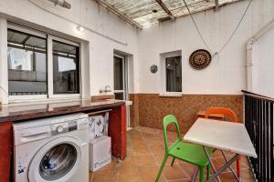 a washing machine in a kitchen with a table and chairs at Casacuéntame in Granada