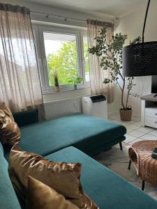 a living room with a green couch and a window at Hostel by BookieBooking in Wiesbaden