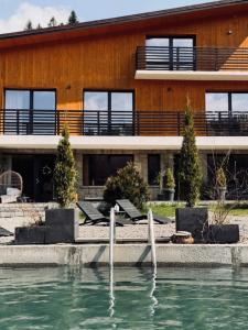 a building with a pool of water in front of a building at Dom i Las in Brenna