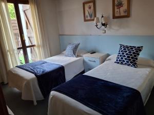a hotel room with two beds and a window at Hostal Casa Juan in Castejón de Sos