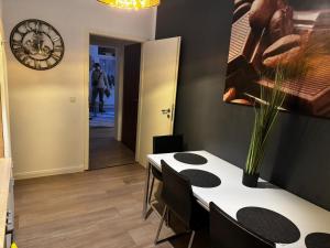 ein Esszimmer mit einem Tisch und einer Uhr an der Wand in der Unterkunft Stadtoase 2 in Wittenberge