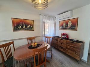 a dining room with a table and chairs and a dresser at Apartment Borna in Baška