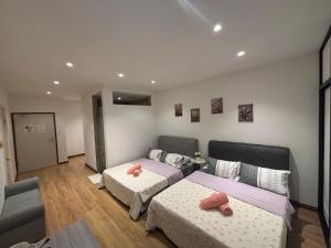 a bedroom with two beds and a couch at Roxy Apartment Kuching in Kuching